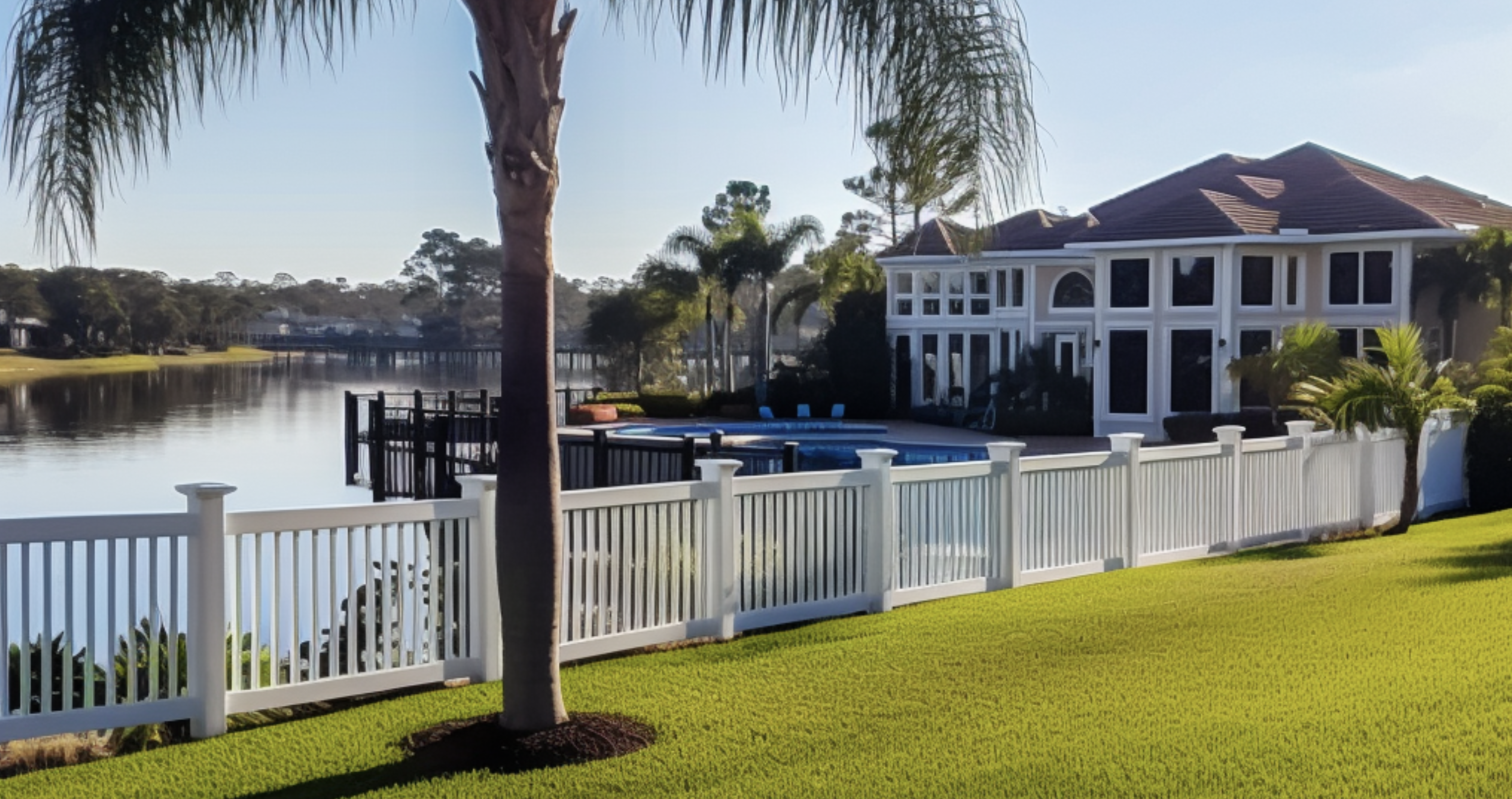A image showing a white vinyl fence against a waterway with mansions in florida
